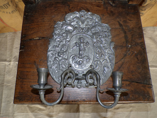 Early twentieth century/earlier hammered pewter sconce with cherub and light-rays detail.