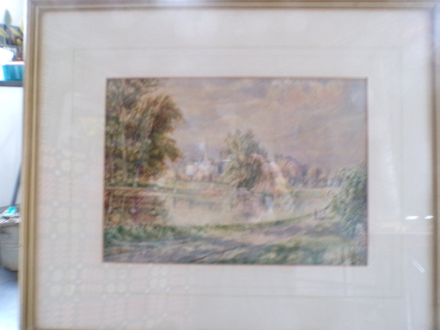 Framed W Bates watercolour of a lake and town scene.