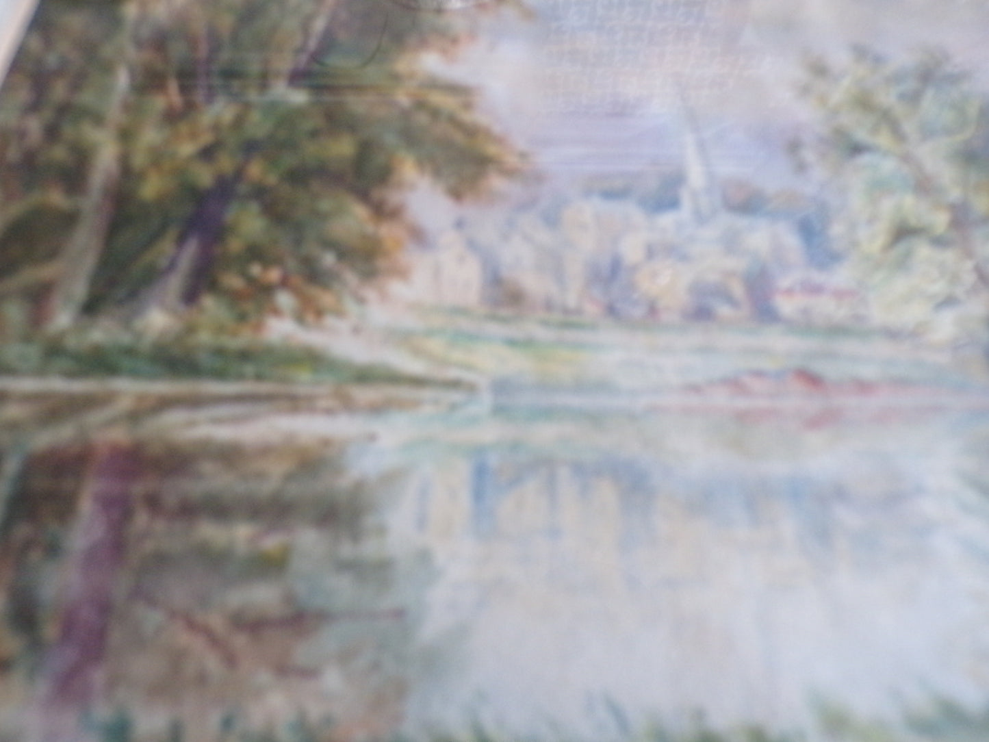 Framed W Bates watercolour of a lake and town scene.