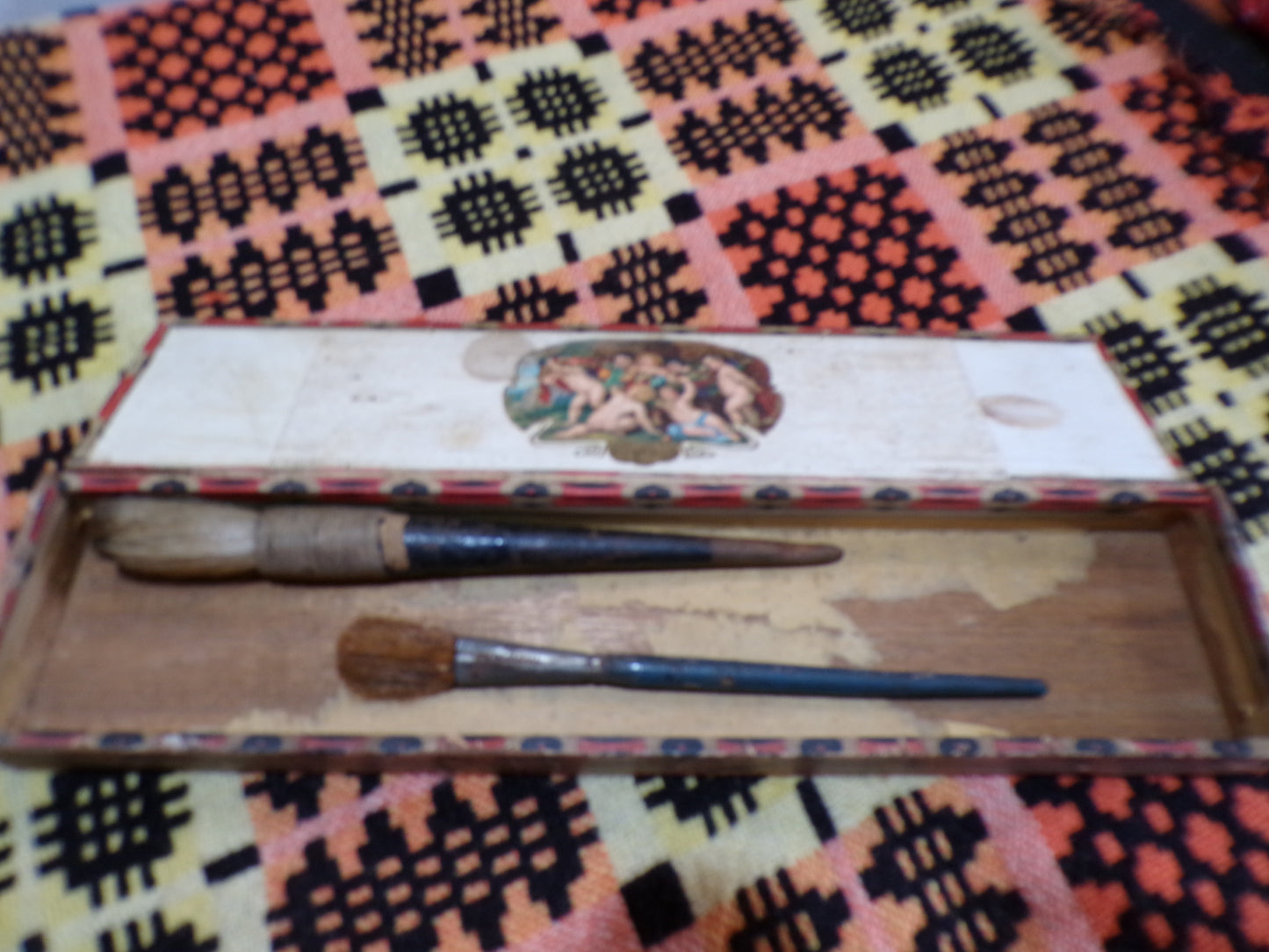 Vintage French soap box containing vintage used painter's brushes with horse hair.